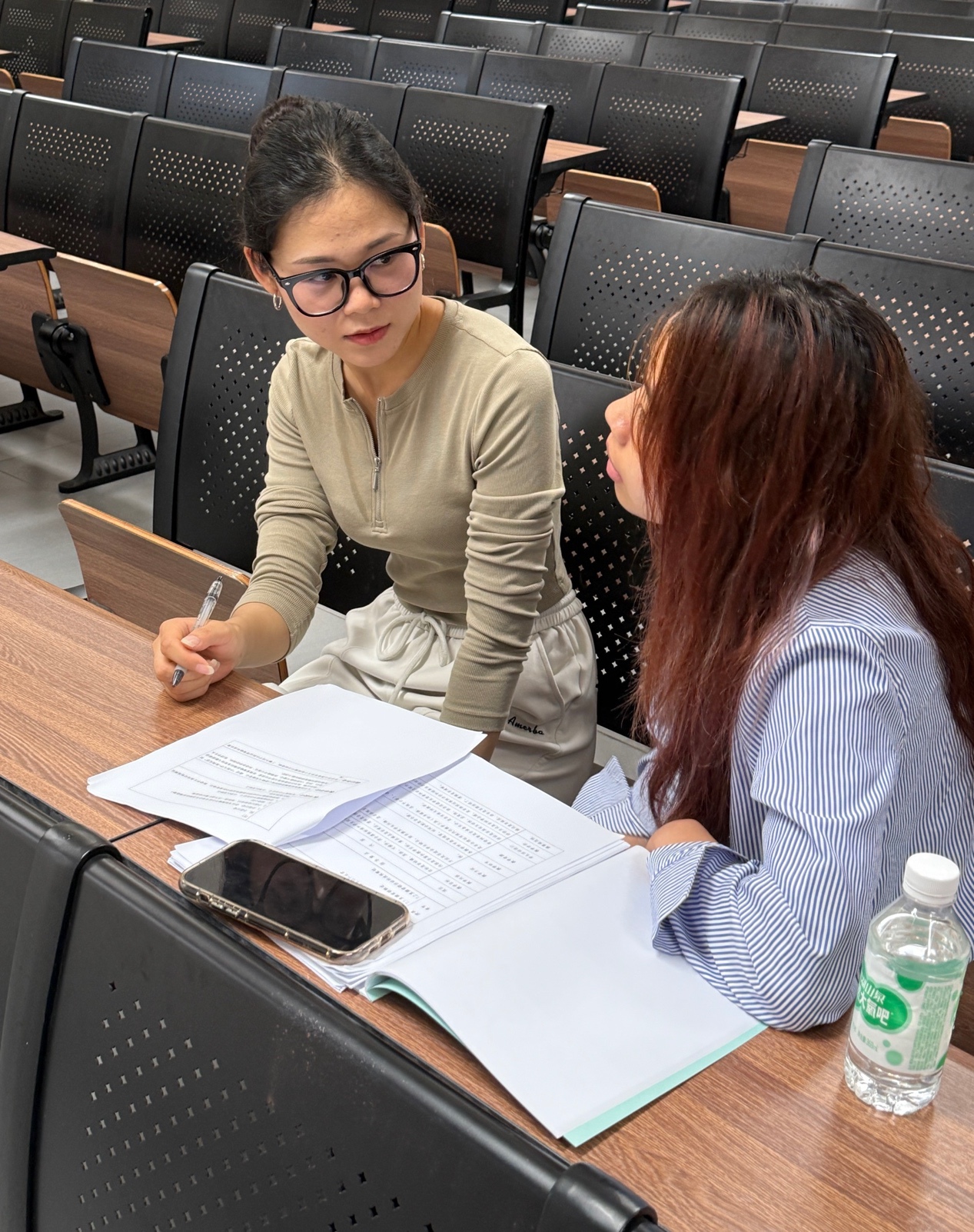 桌子上放着笔记本电脑前的人们
中度可信度描述已自动生成