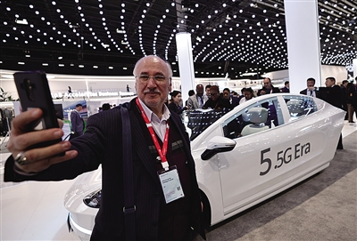 2月28日，在西班牙巴塞罗那举行的2024年世界移动通信大会上，一名参观者在华为展台一辆无人驾驶汽车前自拍。新华社记者 高静 摄