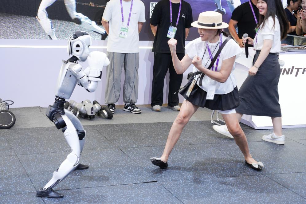 2025年9月19日,在第22届中国—东盟博览会上的人工智能专馆里,一台人形机器人表演“拳击”,与观众互动。新华社记者 周汀鹭 摄