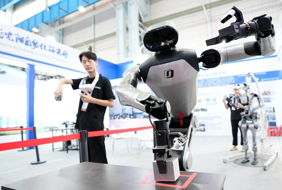 9月5日，在辽宁省沈阳市的2025全球工业互联网大会的展览区现场，中国科学院沈阳自动化研究所的机器人工程师在调试具身智能操作系统。新华社记者 李钢 摄