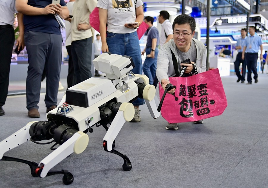 9月6日在2025全球工业互联网大会展览区，一名参观者与联想足式机器人互动。新华社记者 吴青昊 摄