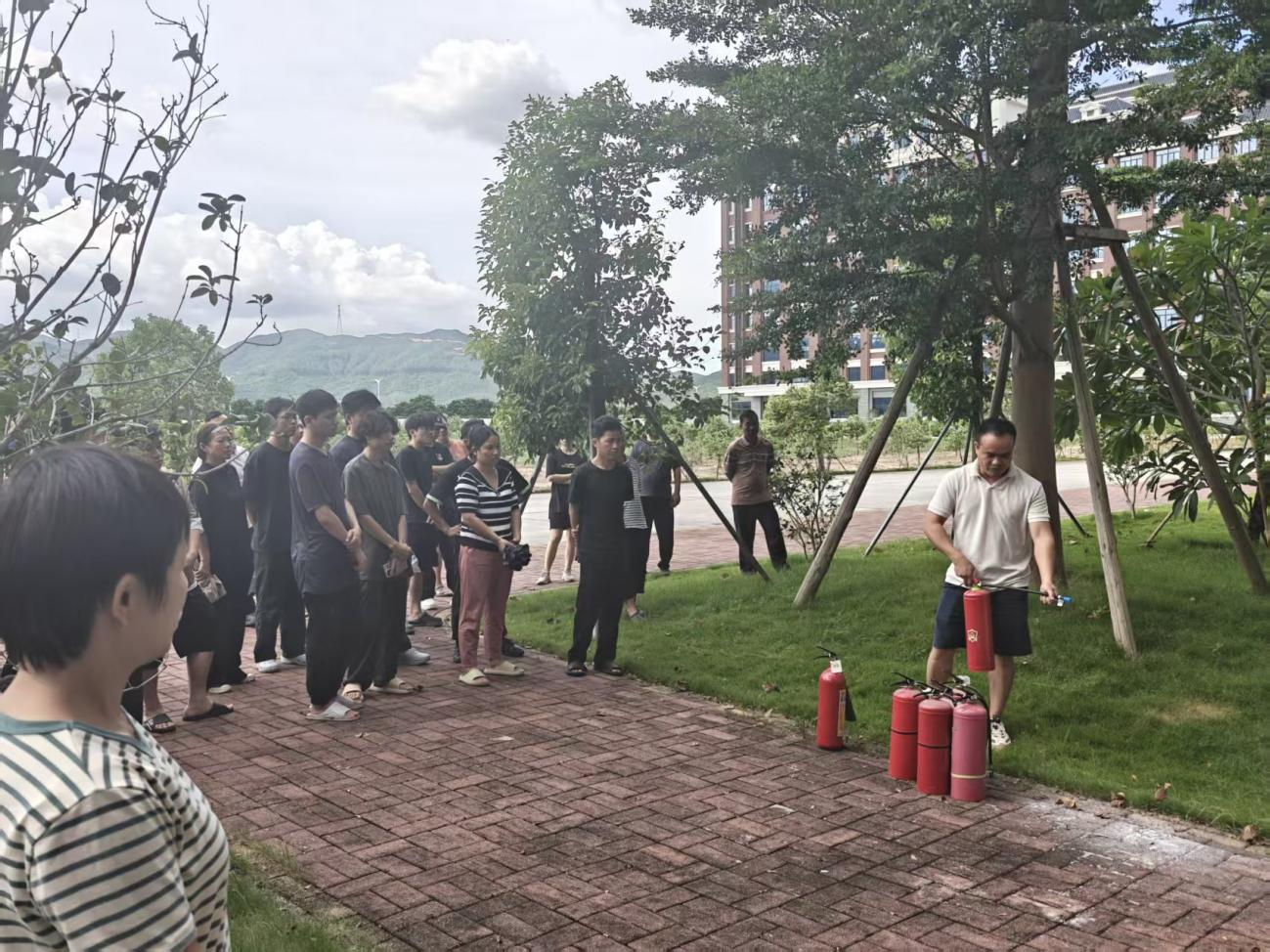 参会人员在室外进行灭火器实操演练（保卫处赵鉴洪副主任现场指导，提升应急处置能力）