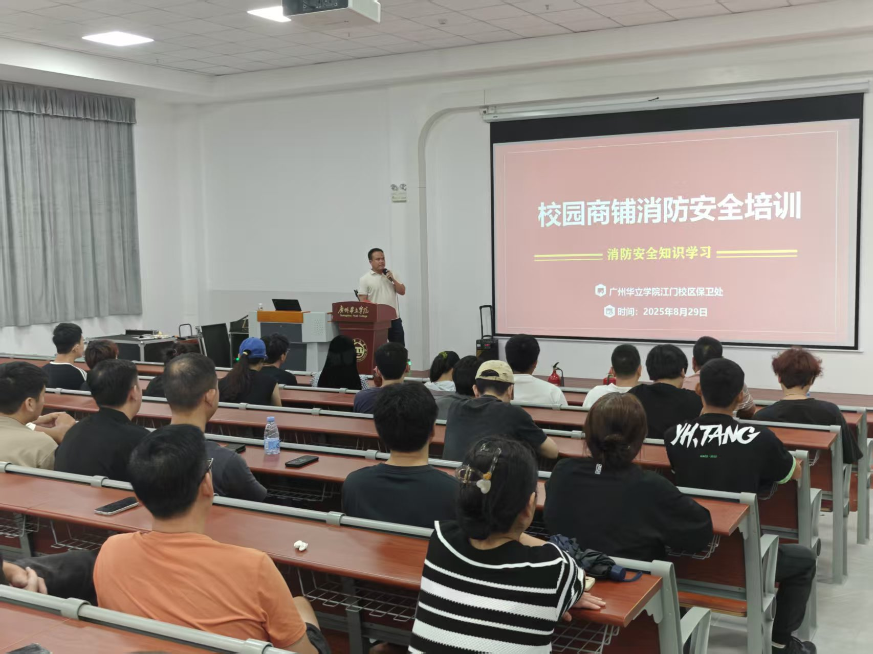 江门校区保卫处开展校园商铺消防安全培训的 PPT 授课现场（内容含消防器材识别、隐患分析）