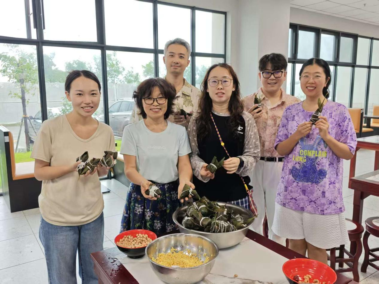 图5：老师们拿着自己亲手包的粽子一起合照留念