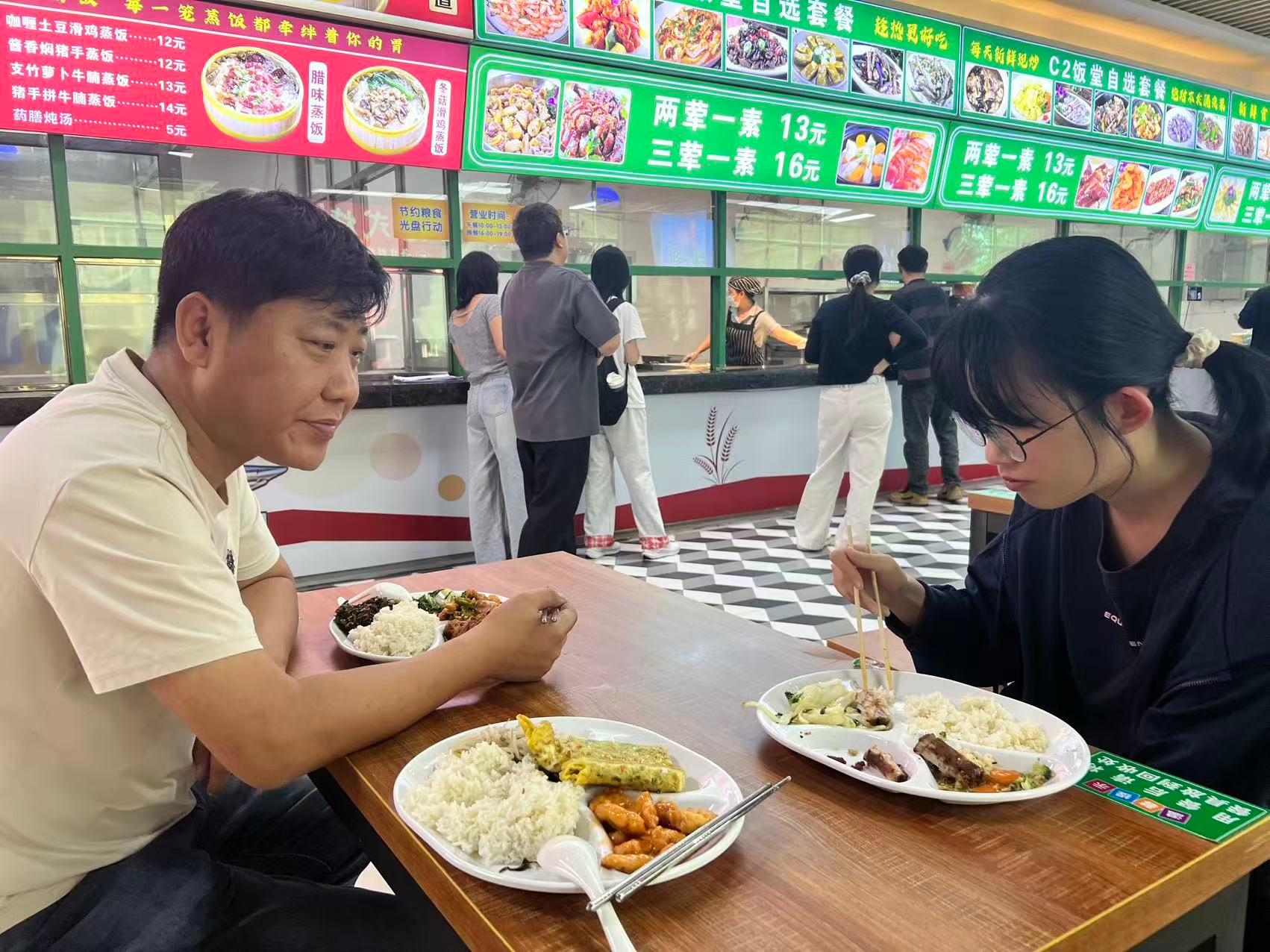 图2 &nbsp;林海校长助理与学生同桌就餐，倾听学生就餐诉求